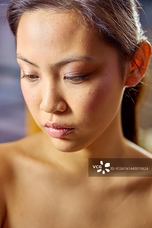 一位向下看的年轻女子的肖像照图片素材