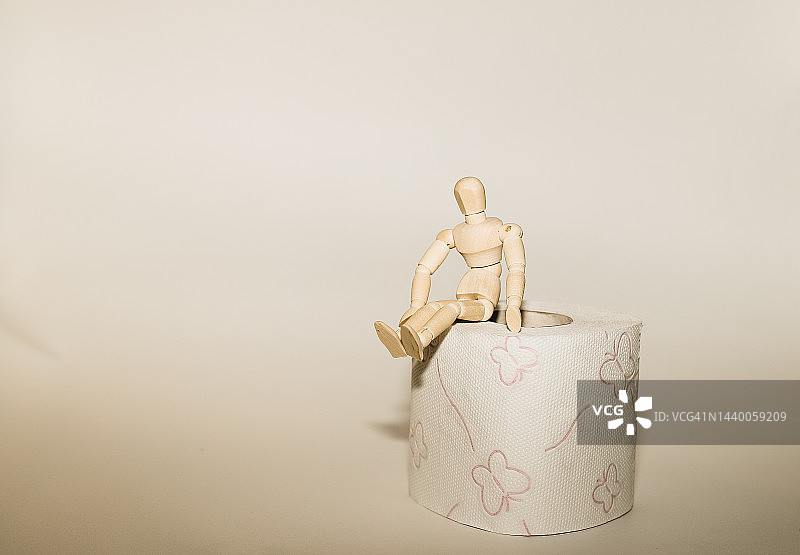 坐在卫生纸上的木制小人图片素材