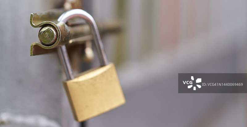 金色挂锁锁在门上（正面角度，背景虚化）图片素材