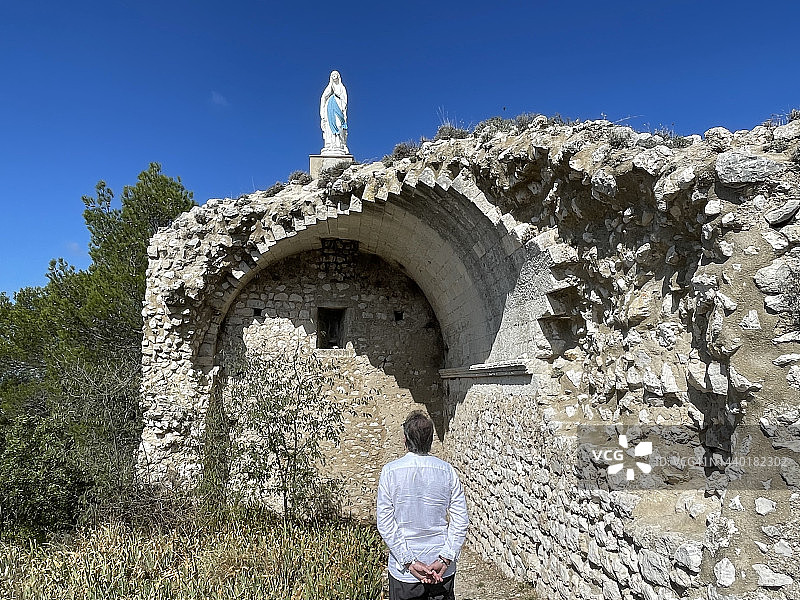 男子仰望法国艾加利埃圣母雕像的背影图片素材