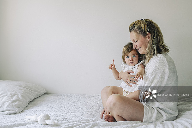 母亲在家中与可爱的女儿互动图片素材