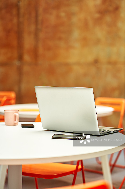 共享办公空间办公桌上的笔记本电脑，空无一人图片素材