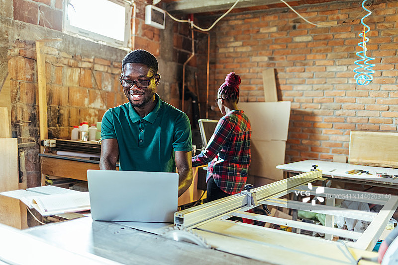 微笑的年轻学生在笔记本电脑上观看网络研讨会图片素材