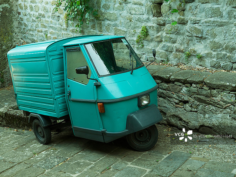 停在石头街道上的小型三轮车图片素材