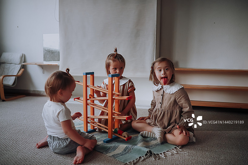 孩子们在儿童中心一起玩玩具，唐氏综合征女孩与孩子们玩耍图片素材