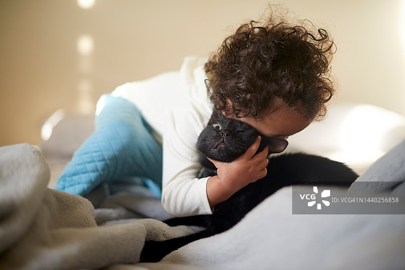 宝宝在家拥抱猫咪，宠物与孩子的亲密互动时光图片素材