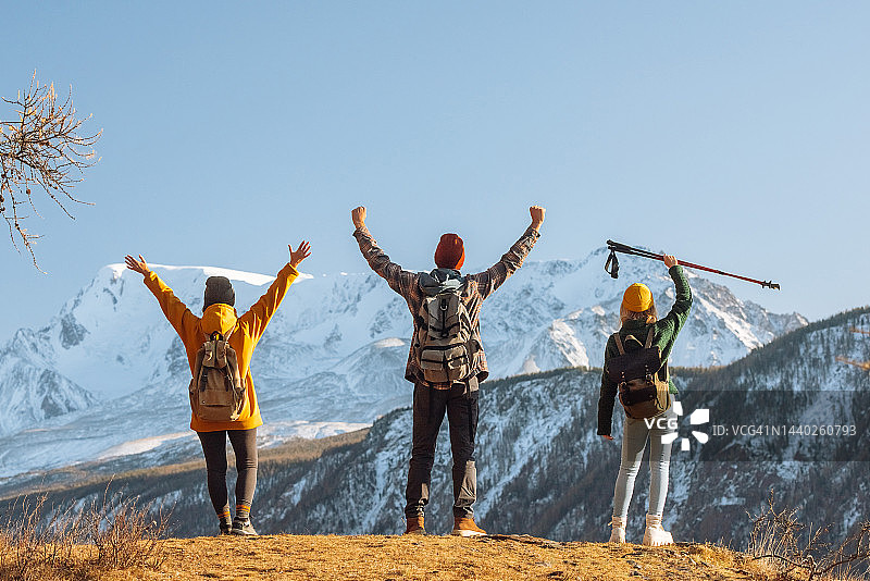 在山顶举起双手的背包人群图片素材
