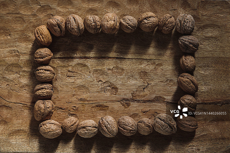木制背景上的天然坚果矩形，复制空间，空框架图片素材