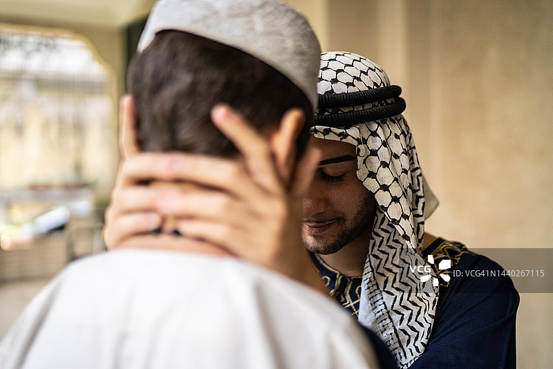 兄弟姐妹在阳台上闭着眼睛碰额头图片素材