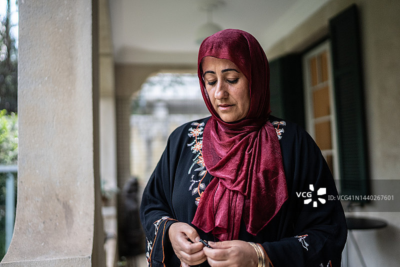 中年伊斯兰妇女在家中阳台祈祷图片素材