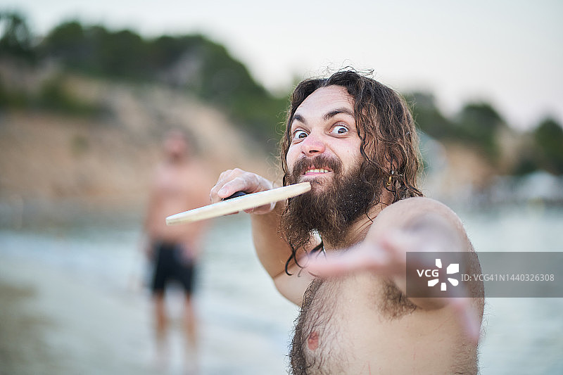 手持网球拍的微笑胡须男图片素材