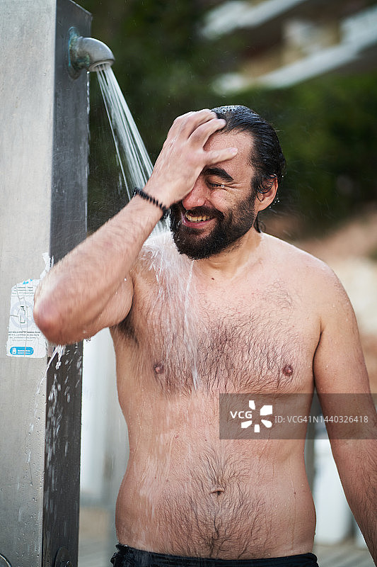 络腮胡男子在公共淋浴区洗浴图片素材