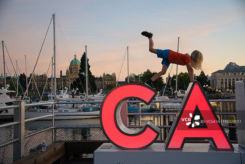 在加拿大温哥华岛维多利亚内港海滨摆姿势的男孩图片素材