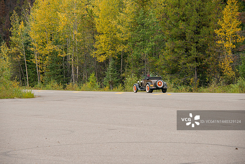 加拿大森林附近道路上的老式老爷车图片素材