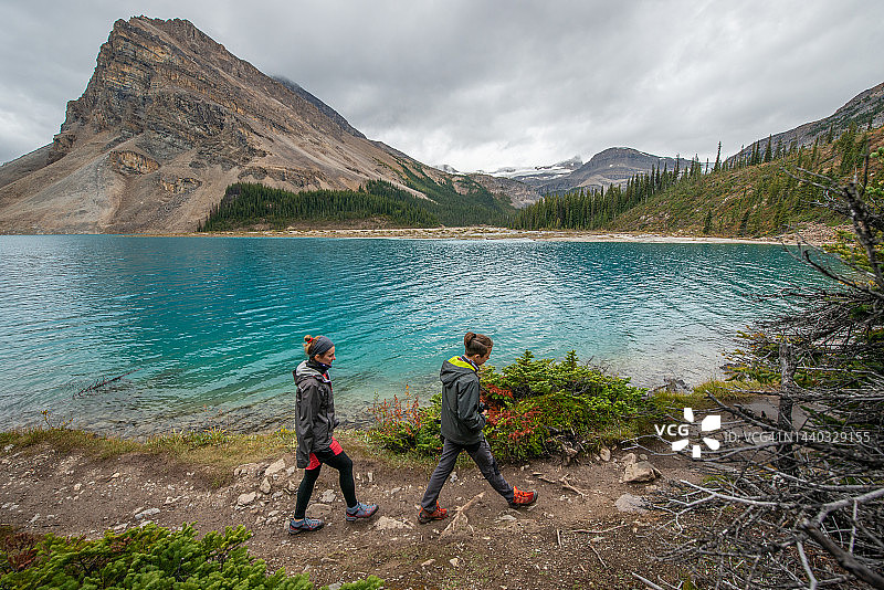 母亲和儿子在加拿大班夫国家公园弓湖附近徒步旅行图片素材