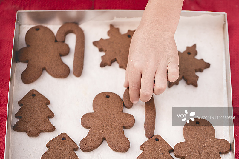 孩子的手够向新鲜出炉的自制雪花姜饼饼干俯视图图片素材