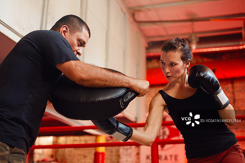 年轻女子与教练一起锻炼图片素材