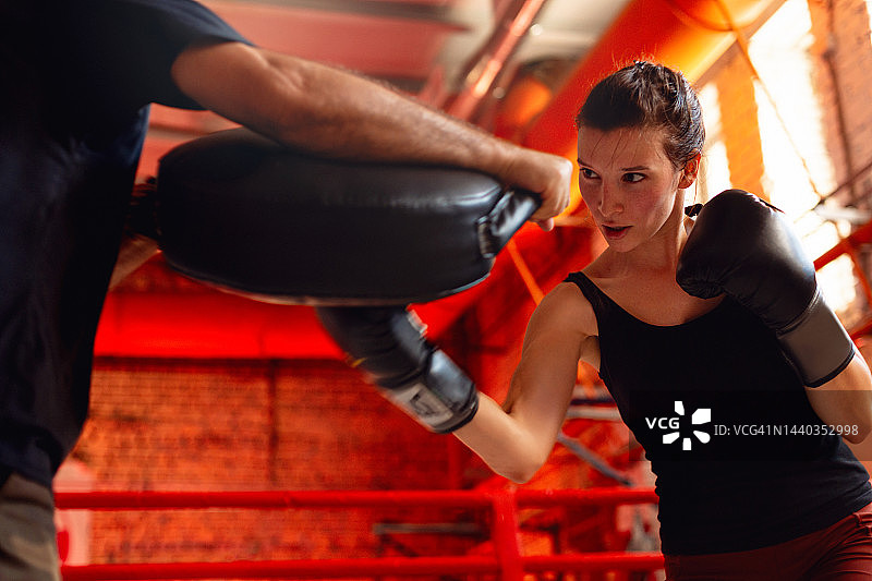 年轻女子与教练一起锻炼图片素材