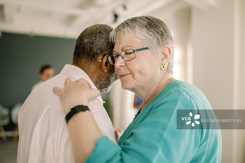 老年妇女在课堂上闭着眼睛与男人跳舞图片素材