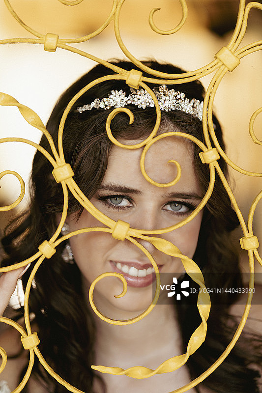 黄色铁栅栏上的十五岁女孩肖像图片素材