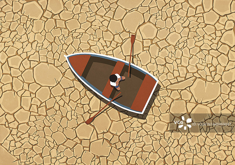 男子坐在干裂的土地上的划艇里图片素材