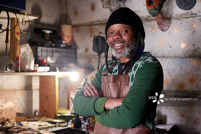 小型企业：工匠和黑人在作坊里身穿皮围裙，使用工具和设备。创意产业启动，工匠在设计工作室里用双手、技能和积极性进行创作图片素材