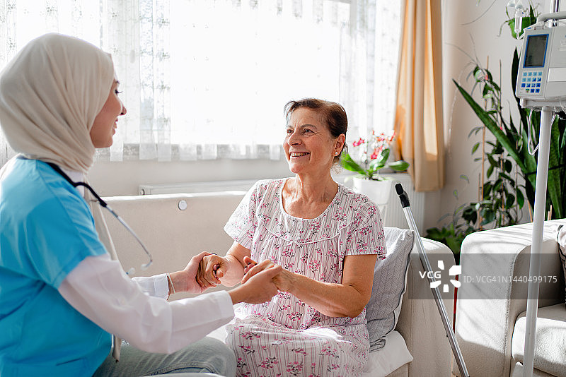 年长的女人与穆斯林护士牵手图片素材
