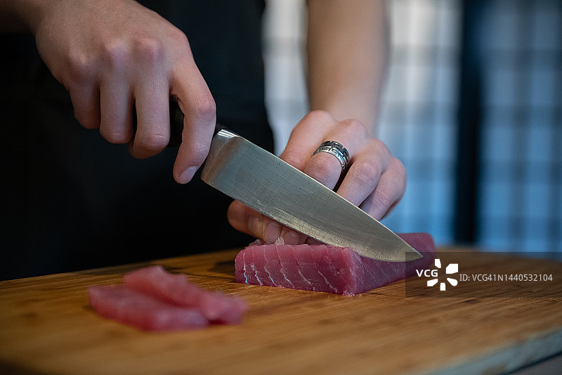 在家制作寿司，在木板上切割金枪鱼图片素材