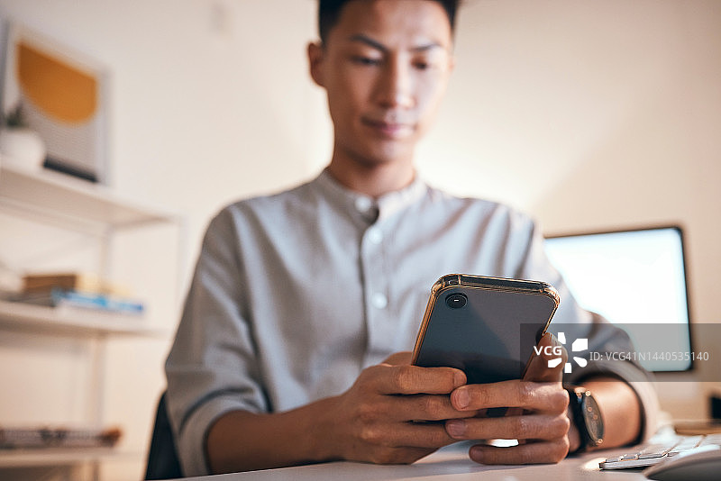 手中拿着智能手机，商务人士在办公室工作休息期间进行社交媒体查看、搜索互联网。亚洲员工使用移动应用程序打字或发送电子邮件。图片素材