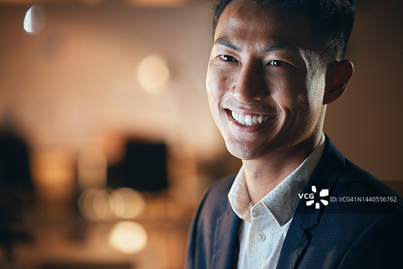 Startup：笑容满面的亚洲商人在办公室熬夜工作图片素材