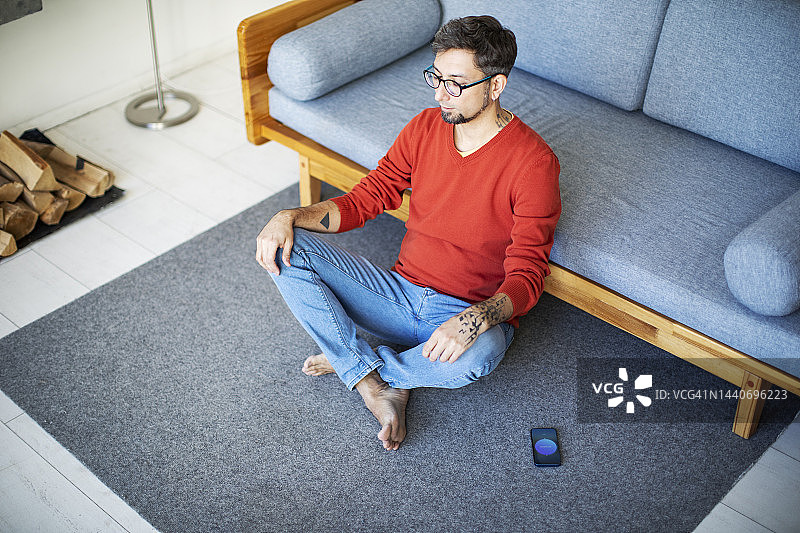 在家用手机冥想的年轻男子图片素材