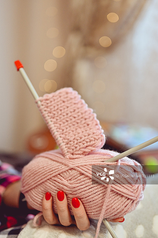 女人手拿粉色线球和编织针特写图片素材