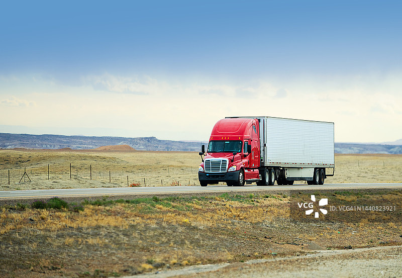 在美国犹他州疾驰的红白相间半挂卡车图片素材