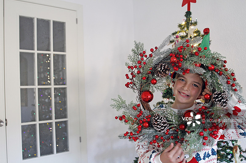 男孩透过圣诞花环看图片素材