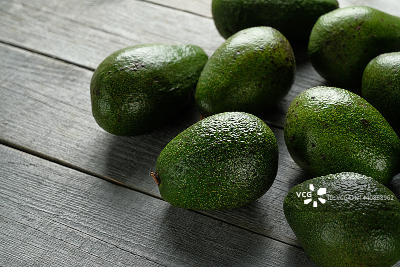 木桌上的绿色成熟牛油果，素食主义概念图片素材