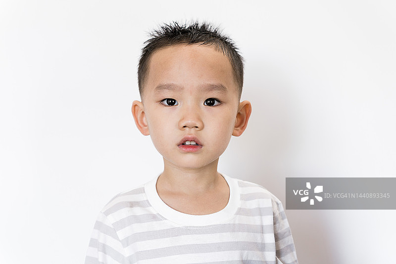 白色背景前的5岁亚洲男孩肖像图片素材