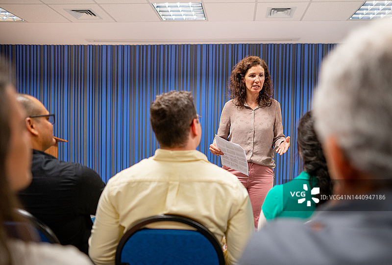 女人在研讨会上向观众发表演讲图片素材