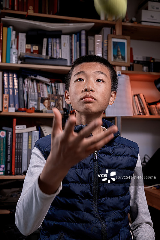 男孩在书架前抛网球图片素材