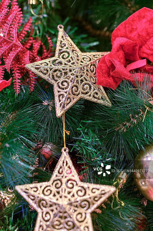 金色圣诞星挂在圣诞树上图片素材