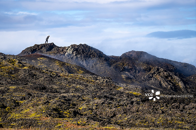 男人在Leirhnjukur火山地区悬崖边向下看图片素材