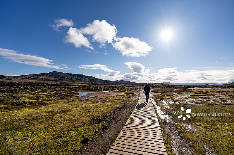 独自走在Leirhnjukur火山地区木板路上的男人图片素材