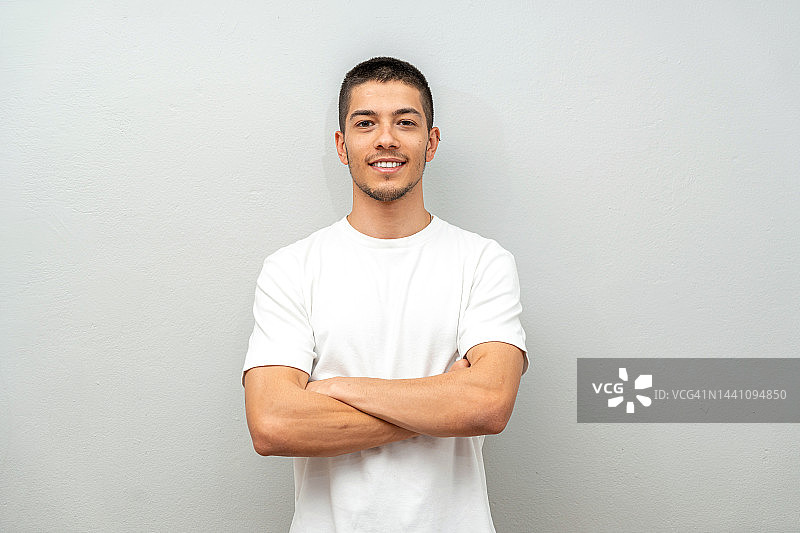在灰色墙壁前的年轻男子肖像照图片素材