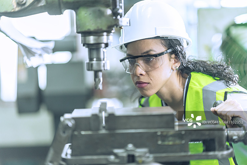 女工程师在车床上加工内燃机汽车零件图片素材
