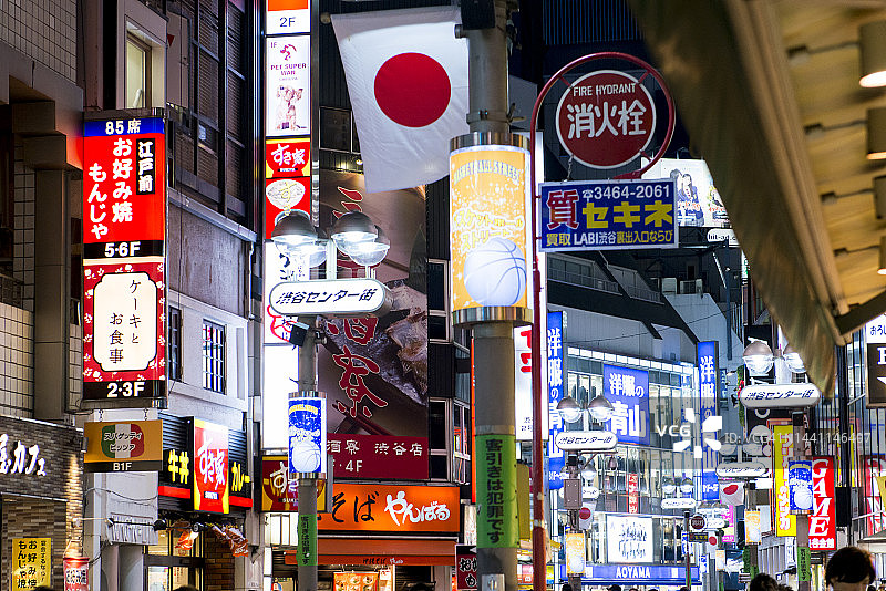 夜晚日本东京涩谷地区的街道上被霓虹灯广告牌照亮图片素材