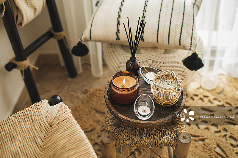 明亮舒适的客厅里，木制咖啡桌上点燃的蜡烛家居装饰图片素材