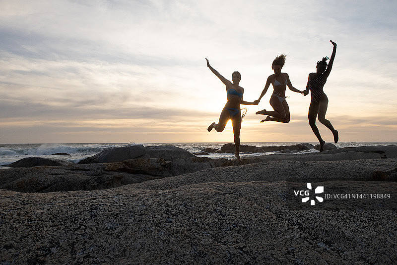 三个年轻女性兴奋地跳跃的剪影图像图片素材