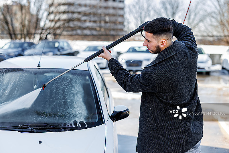 年轻人用高压水冲洗汽车图片素材