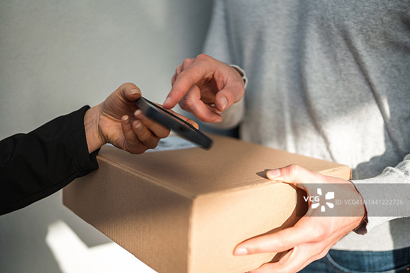 客户在智能手机上签收包裹图片素材