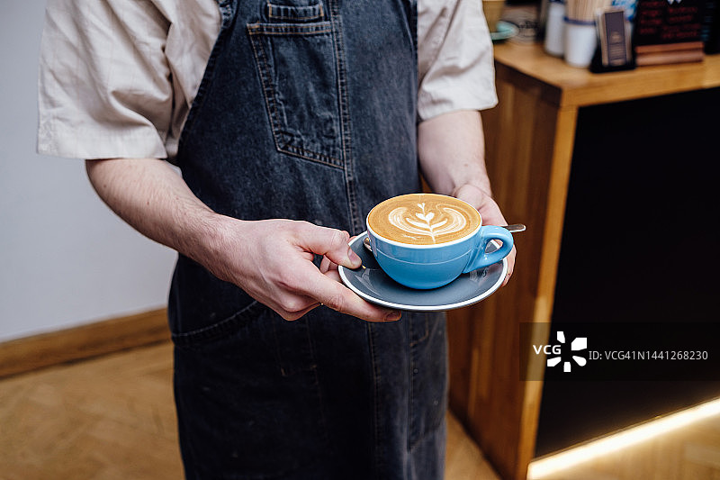 服务员端着咖啡杯的局部照片图片素材