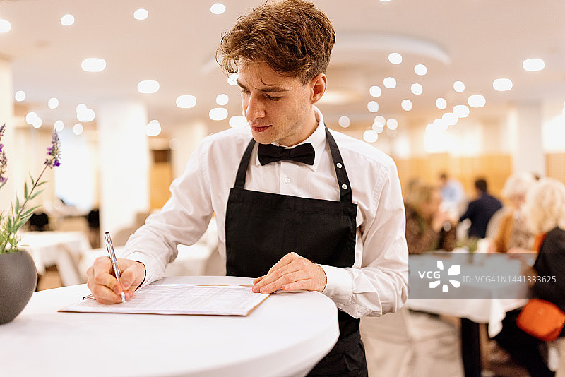 服务员填写自助早餐和餐厅的客人名单图片素材